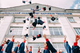 Hand throwing student hats in the air