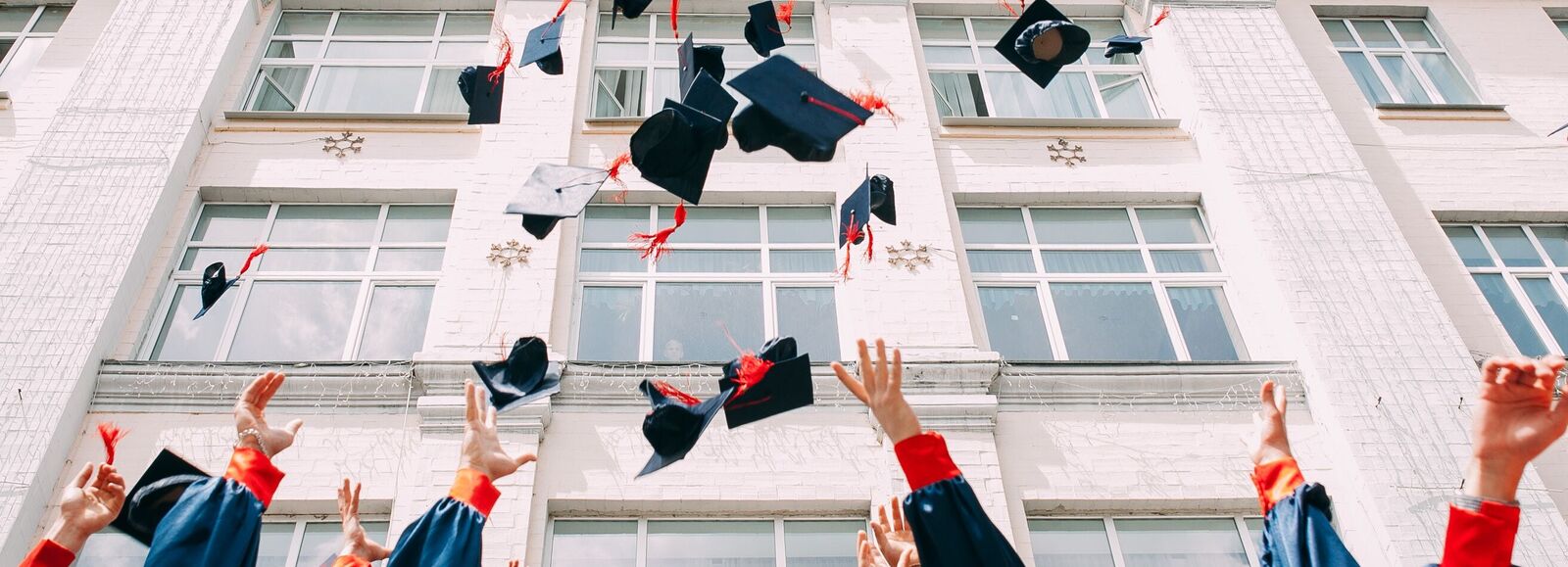 Hand throwing student hats in the air